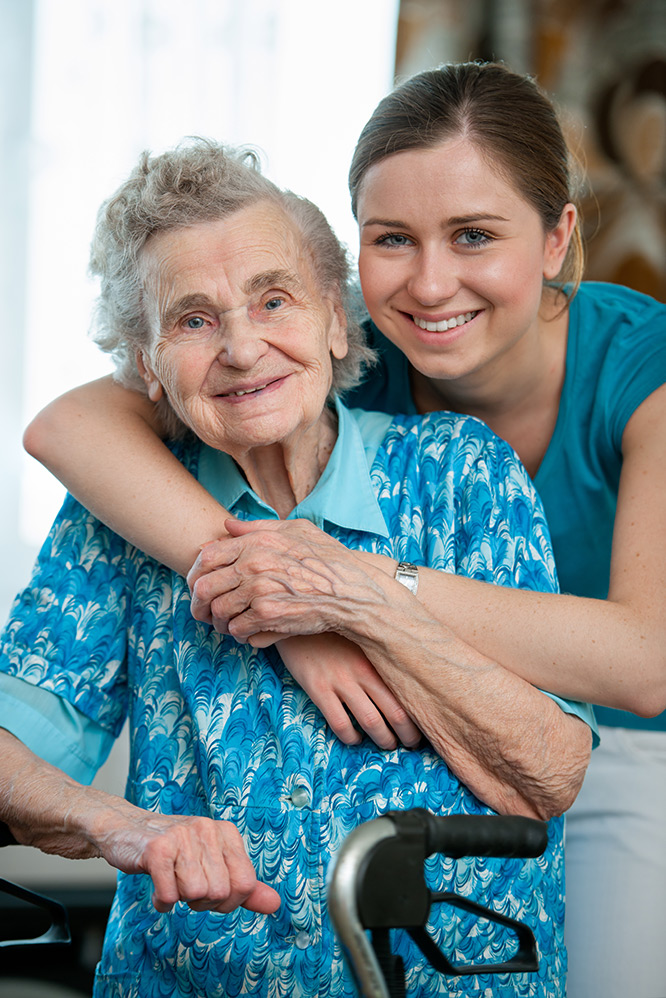 Smiling senior woman with younger care worker