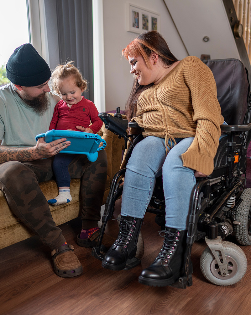 Young mother in wheelchair spending time with daughter and husband